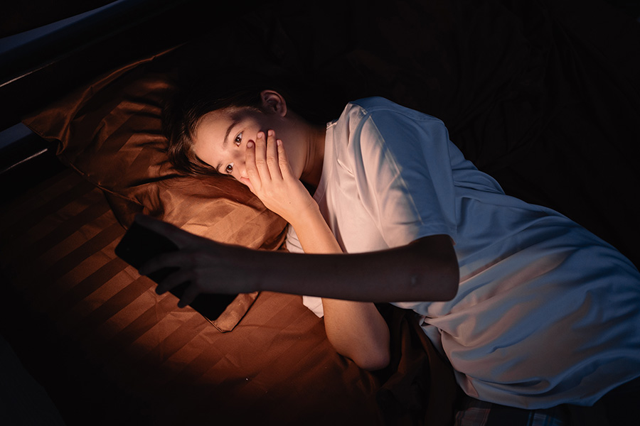 A girl looking at a phone with an alarmed expression