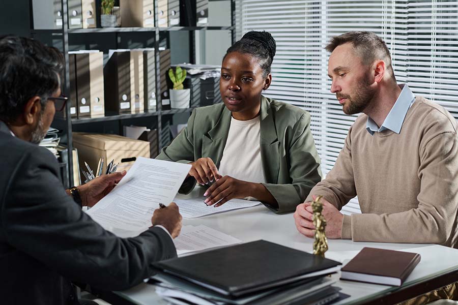 A couple in an office with a solicitor explaining papers