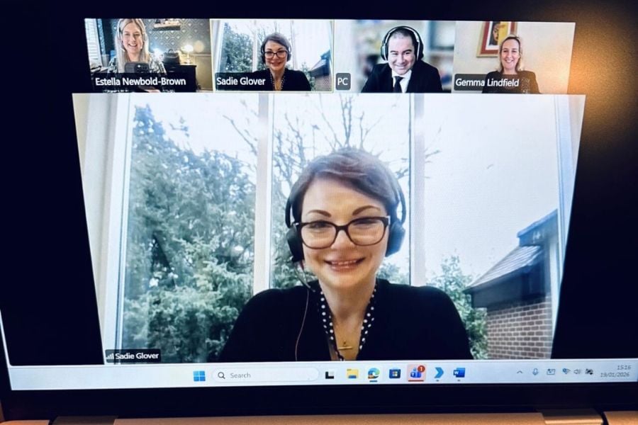 Two podcast hosts and two guests can be seen on a computer screen