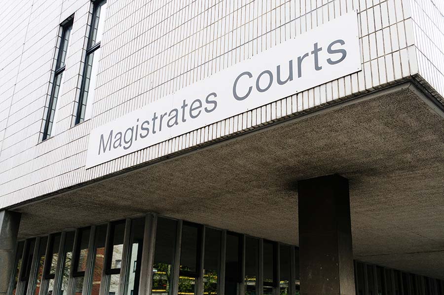 An exterior 'magistrates courts' sign on a modern building