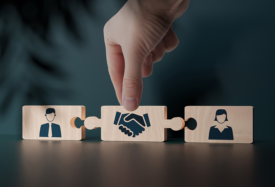 Simple images of a man and woman printed on wooden blocks, with a block printed with a handshake linking the two