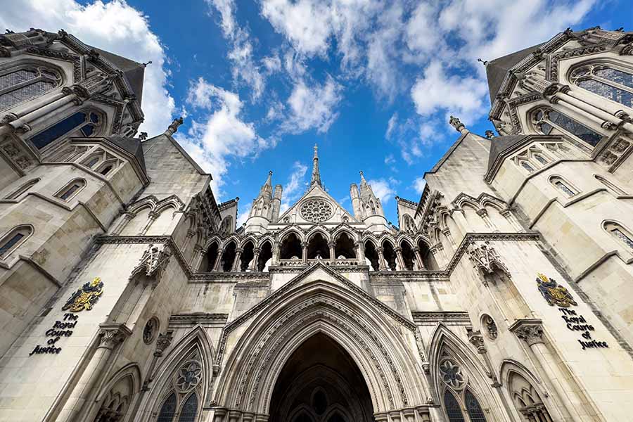 A wide shot of the exterior of the royal courts of justice, view from below