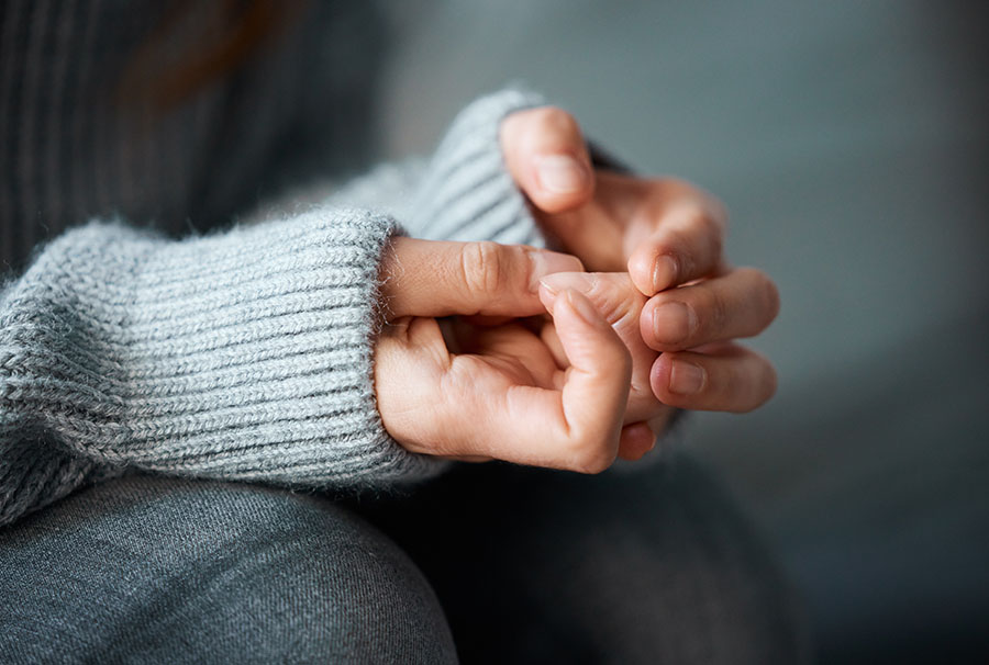 A close-up of a woman's hands, she appears to be fidgeting indicating she's upset