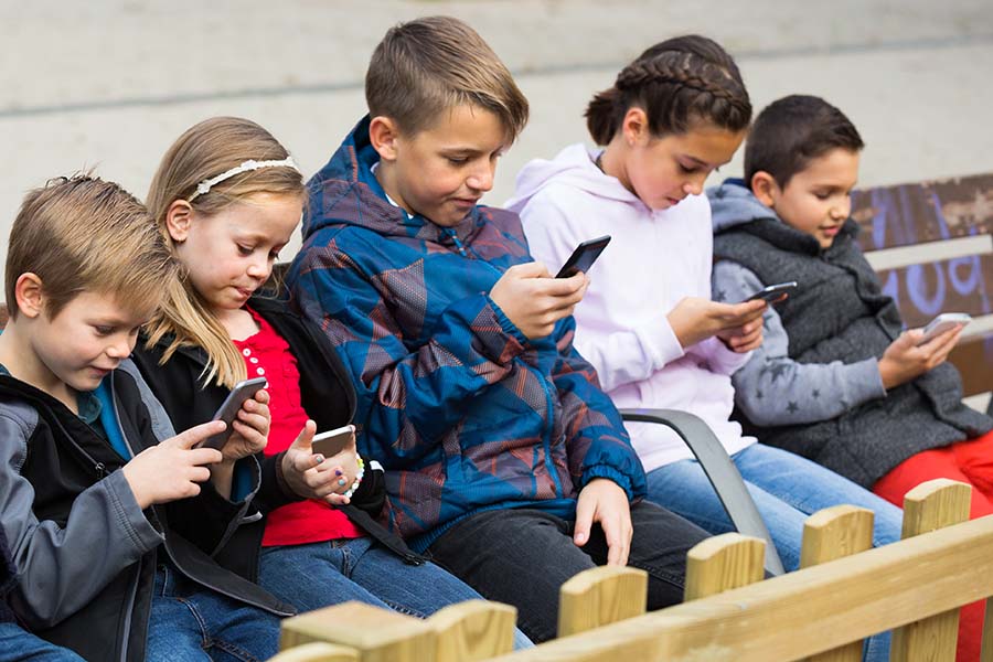 A group of young children looking at phones