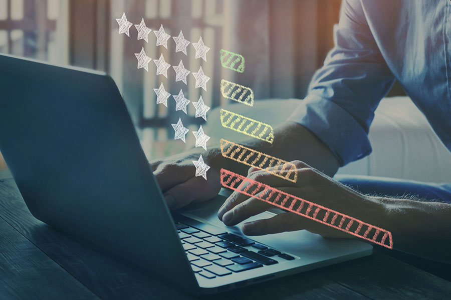 Close-up of hands on a laptop with a bar chart overlaid lots of one star reviews