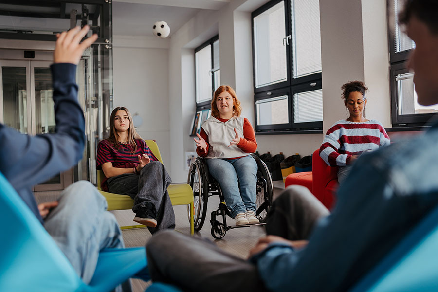 A diverse group of young people sitting in chairs in a circle