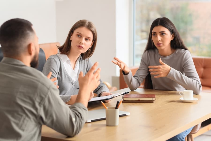 Couple arguing in a meeting room with a mediator