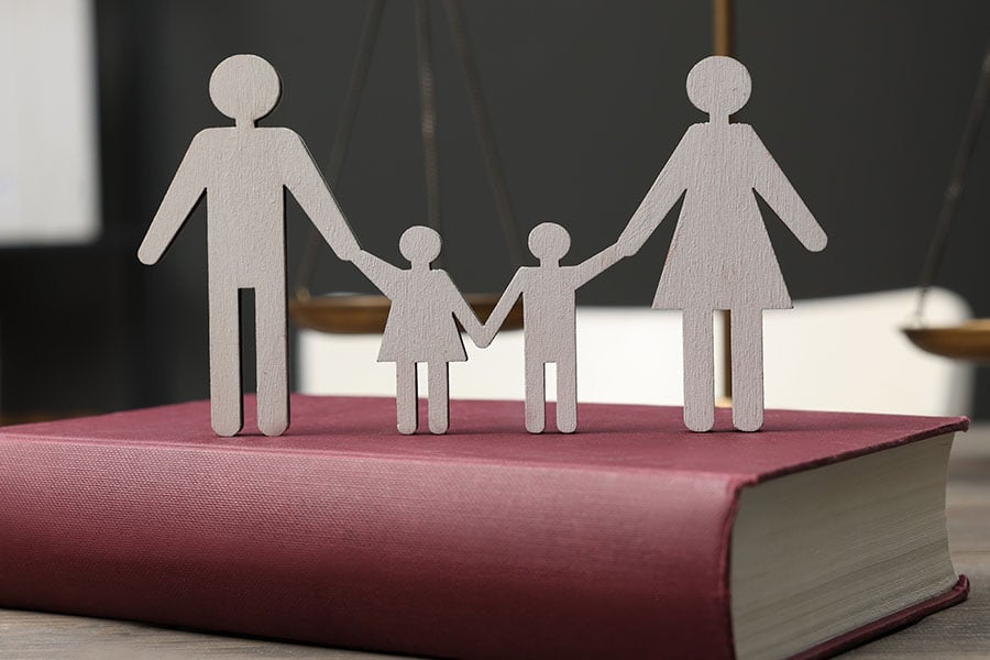 Paper cut-outs of a family with placed on top of a law book