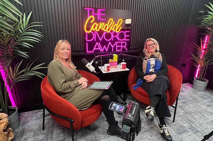 Kimberley Davies and Helen Thorn in a studio in front of a neon sign which reads The Candid Divorce Lawyer