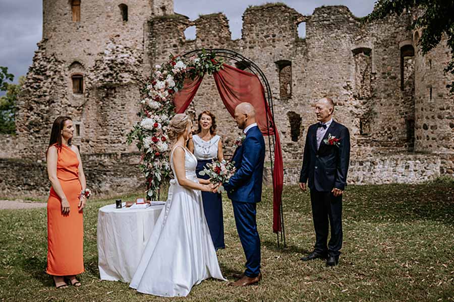 An outdoor wedding ceremony in the grounds of a ruined castle