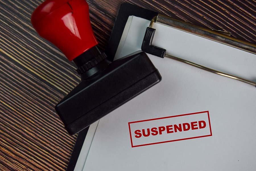 The word suspended stamped in red on a piece of paper